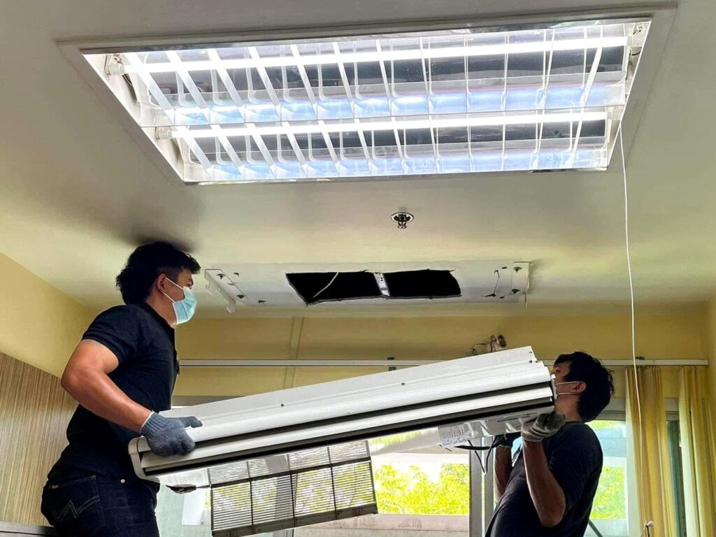 ช่างของเอสแอนด์ดับบลิว ไฮสปีด สองคนกำลังติดตั้งเครื่องปรับอากาศแบบฝังฝ้าในสำนักงานของลูกค้า